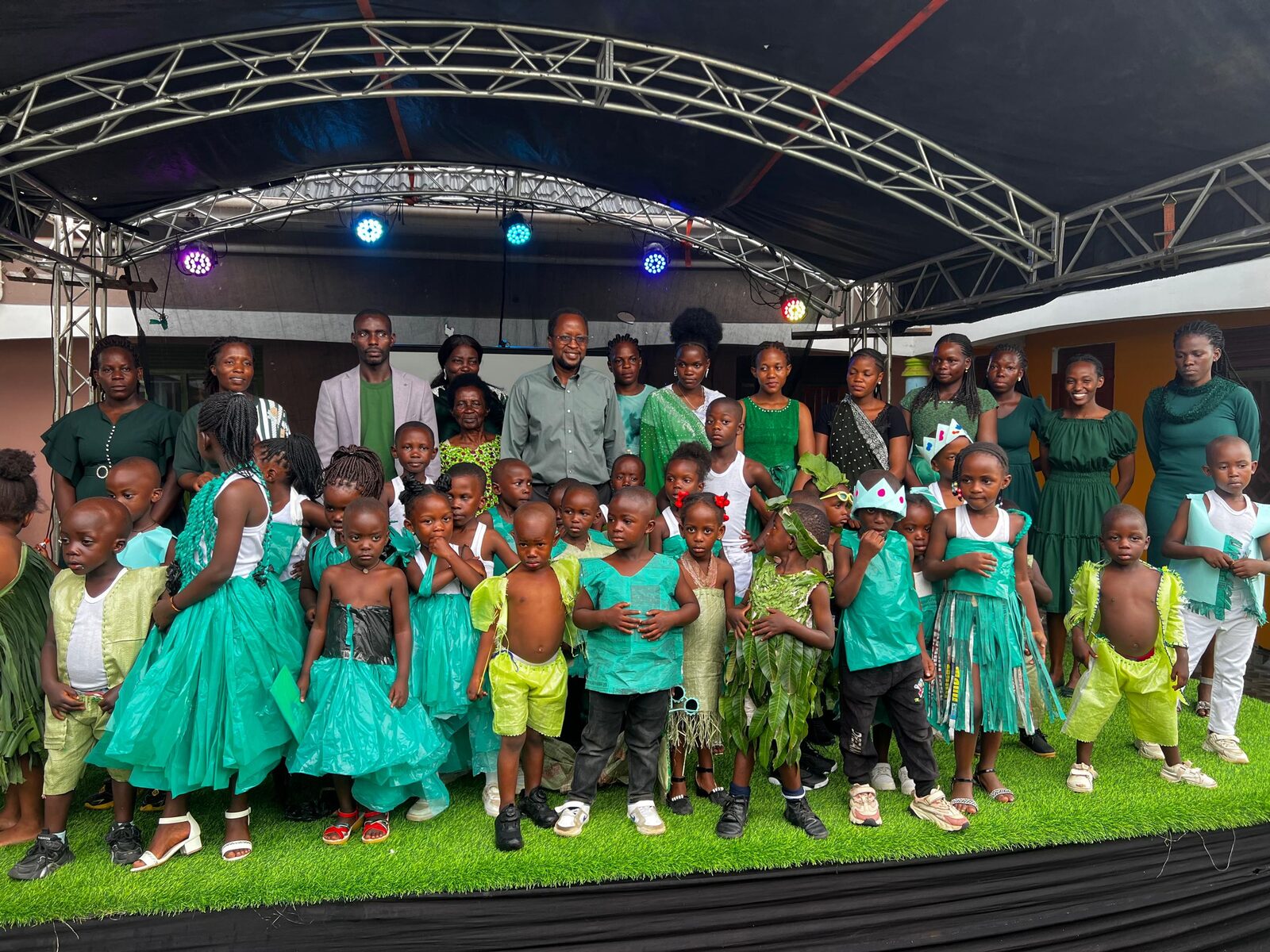 Staff and children on stage together for Green Color Day at Goshen Children's Care Centre