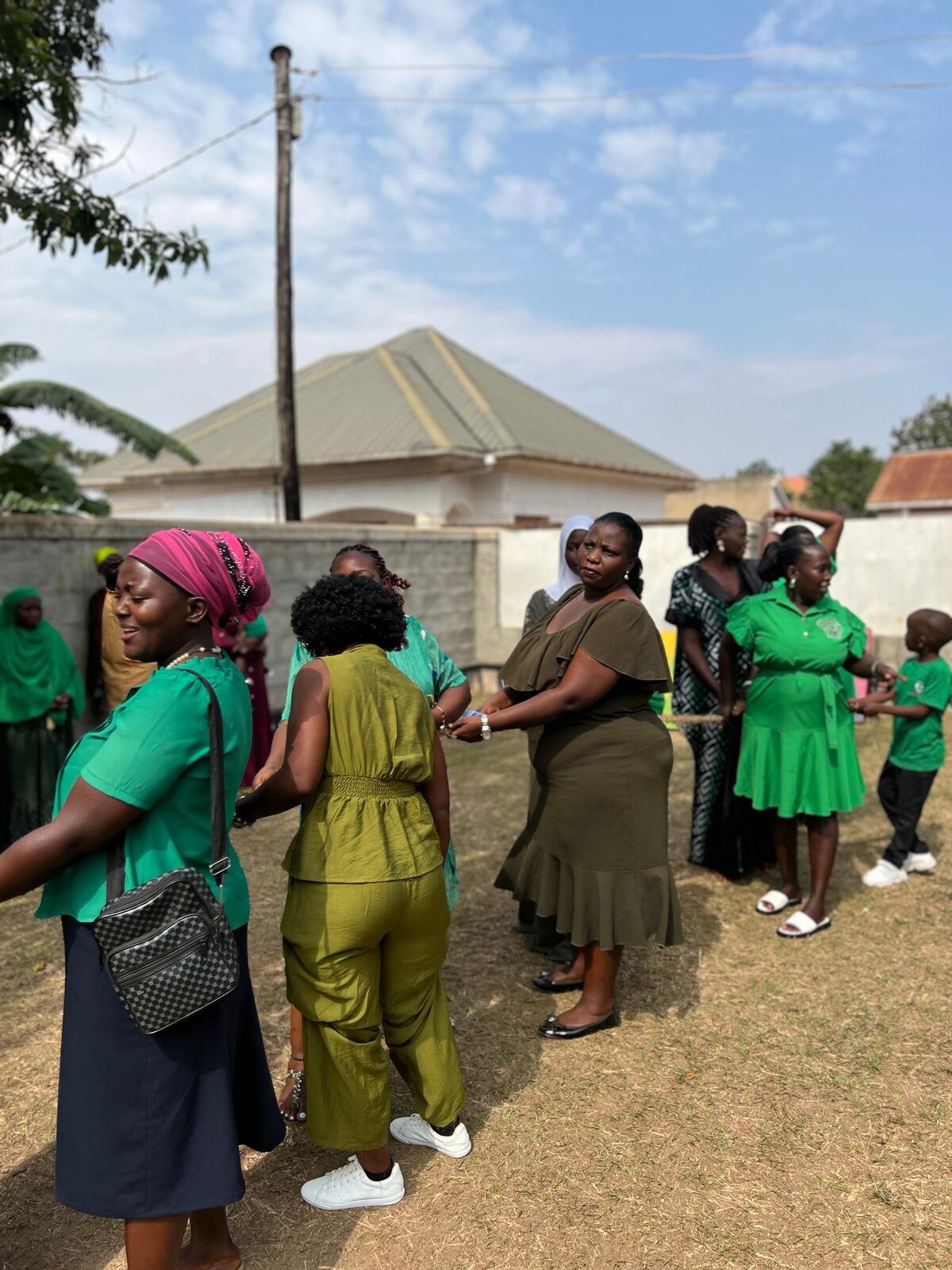 Staff members playing a rope game outdoors during Green Color Day
