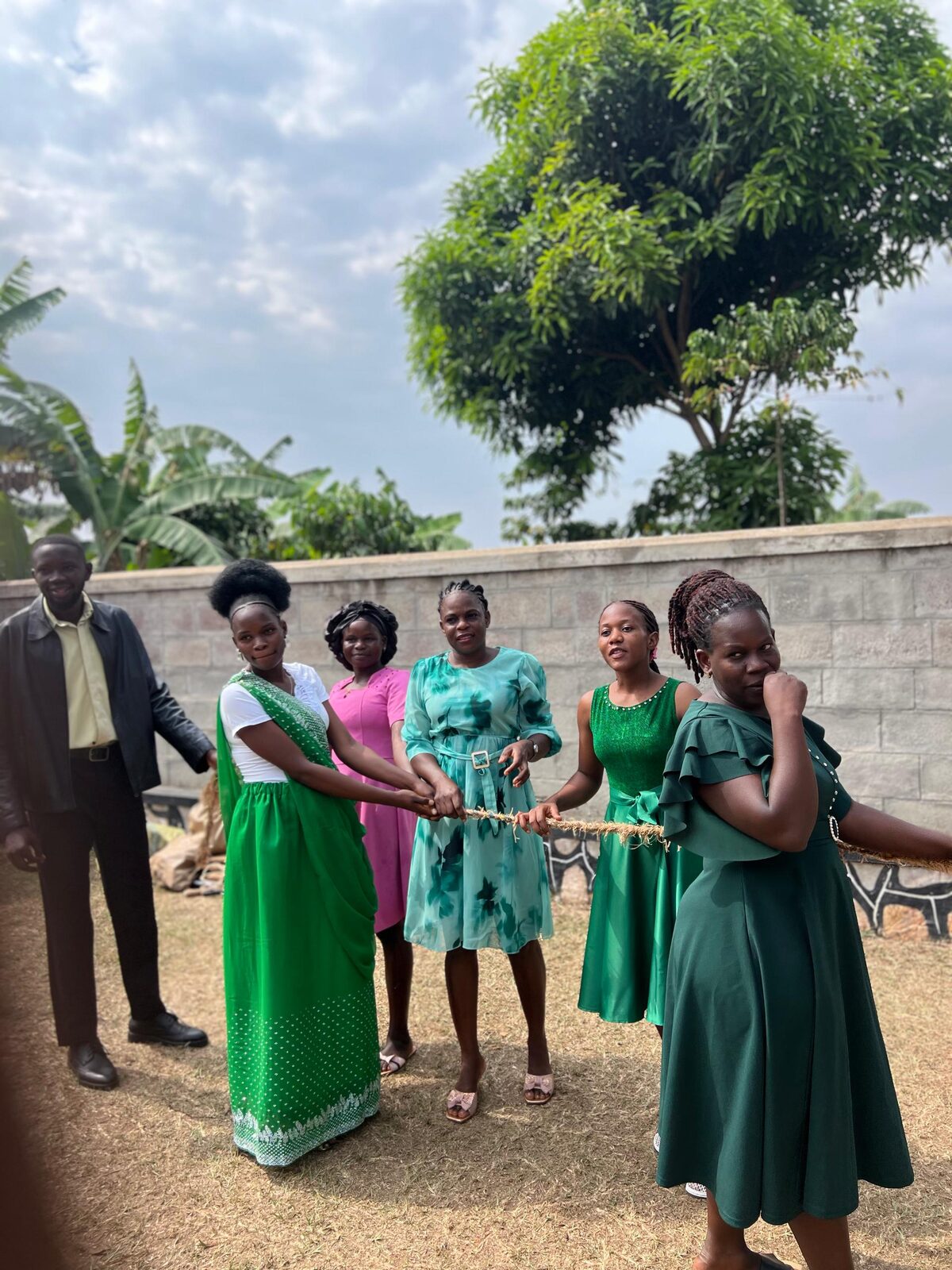 Staff members in green outfits holding a rope together for a group game